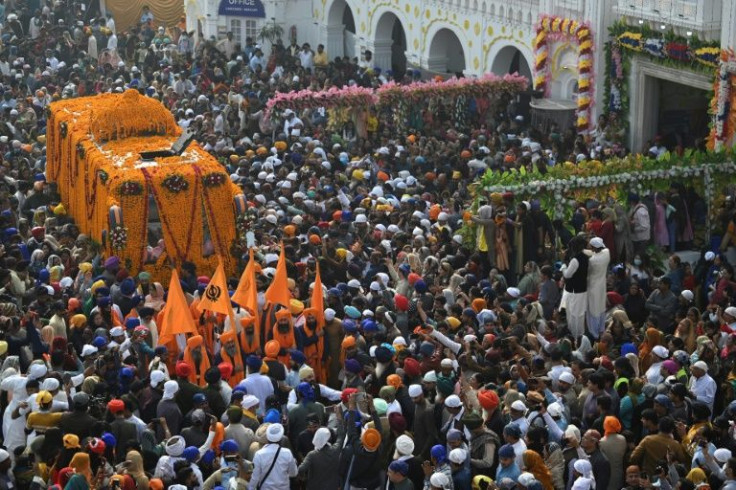 Pilgrims surround a bus carrying the Guru Granth Sahib (Sikh holy book) on the birth anniversary of Guru Nanak Dev, the founder of Sikhism