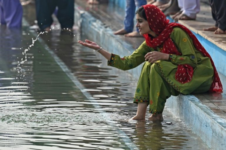 A Sikh pilgrim sits next to the holy sarovar or sacred pool on the birth anniversary of Guru Nanak Dev, the founder of Sikhism