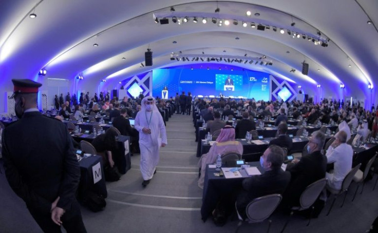 People look on as US Secretary of Defense Lloyd Austin gives a speech during the IISS Manama Dialogue