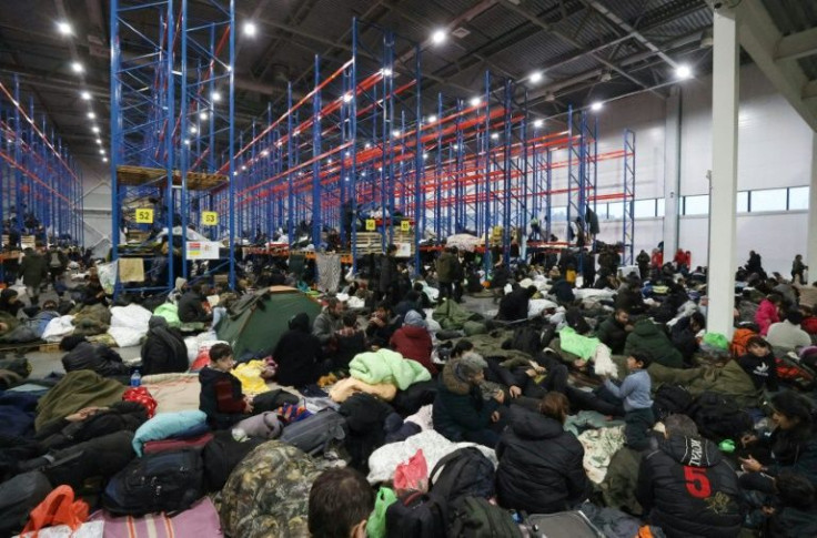 Around 2,000 migrants who had been camped out in freezing conditions at Belarus's border with Poland spent the night in a logistics centre after their camp was cleared by border guards