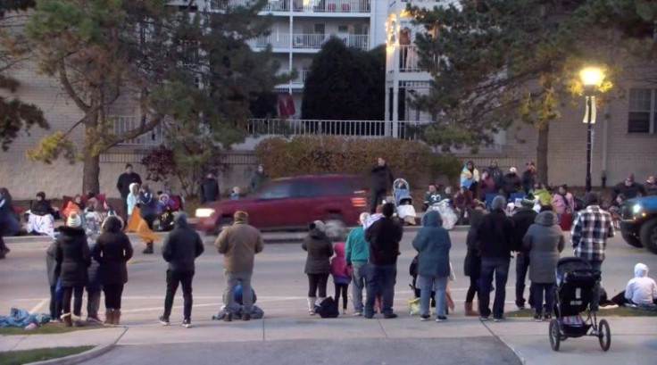 A red SUV is seen speeding through the holiday parade crowd in the city of Waukesha, Wisconsin via a video screen shot taken from the city's Facebook live streaming on November 21, 2021