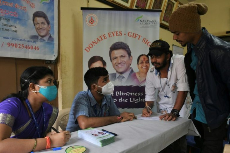 A volunteer fills an eye donation pledge form during an event organised in memory of Rajkumar