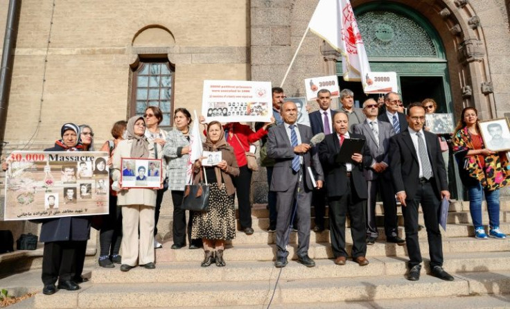 People protest on the first day of the war crimes trial of Hamid Noury, a former Iranian prison official accused of handing out death sentences during a 1988 purge