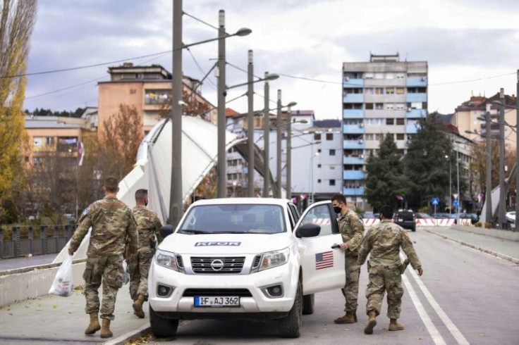 US troops part of a NATO force patrol the Ibar rover bridge which divides Mitrovica