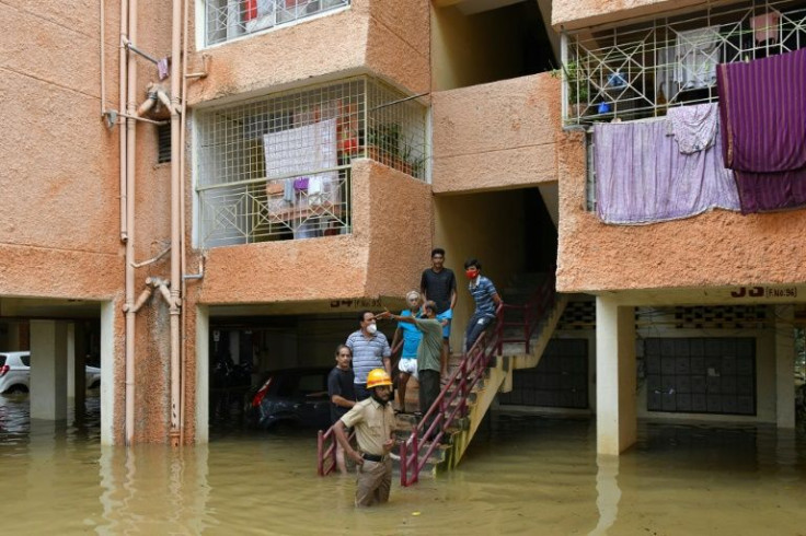 Residents outside a flooded apartment block in Bangalore