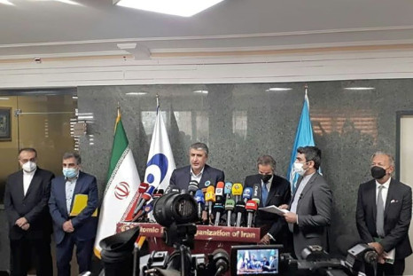 A handout picture provided by Atomic Energy Organization of Iran (AEOI) shows UN nuclear watchdog chief Rafael Grossi (C-R) and the head of Iran's Atomic Energy Organization, Mohammad Eslami (C-L), speaking in Tehran on November 23, 2021