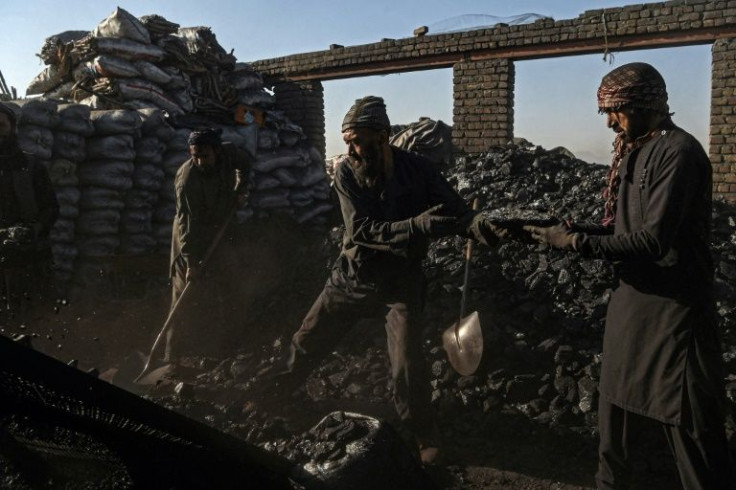 Day labourers unload coal at a coal yard on the outskirts of Kabul