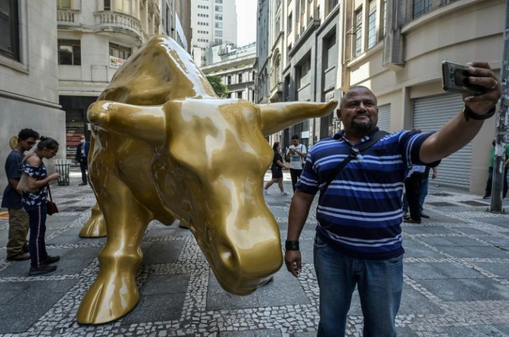 A man makes a selfie with a replica of the "Charging Bull" (known as the Wall Street Bull) statue outside Sao Paulo's Stock Exchange headquarters in NOvember: the bull has now been removed following protests