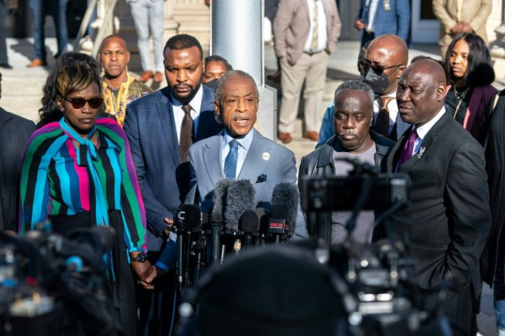 The Reverend Al Sharpton, center, with Wanda Cooper-Jones, mother of Ahmaud Arbery, left, attorney Lee Merritt, second from left, attorney Ben Crump, right, and Marcus Arbery, father of Ahmaud Arbery, addressing reporters