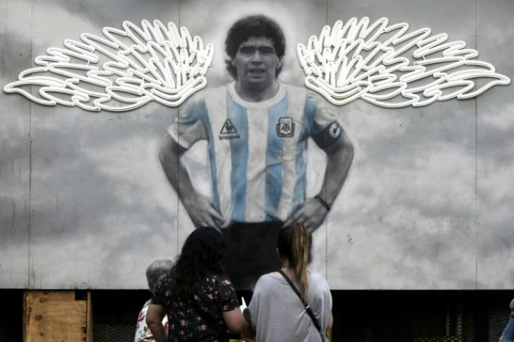Murals in Buenos Aires show Maradona sporting angel wings, as a patron saint complete with halo and scepter, or back here on Earth, kissing the World Cup