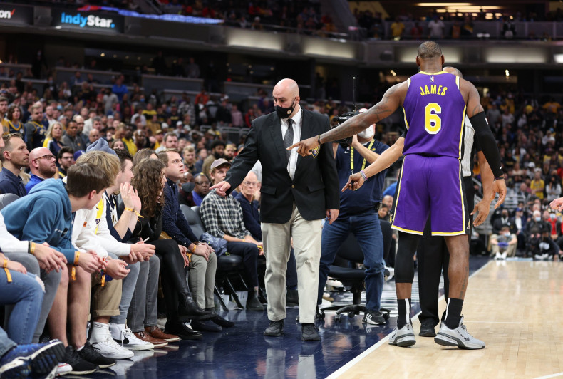 LeBron James #6 of the Los Angeles Lakers points out fans that he had a disturbance with to security