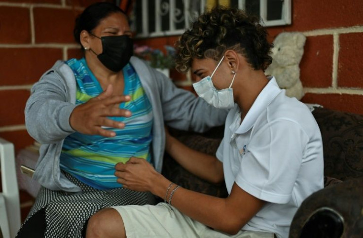 Lesly Madariaga (L) is pleased her teen son Wilmer Rodriguez works as a barber in their neighborhood in Tegucigalpa, Honduras, but she fears he will try to migrate illegally to the United States