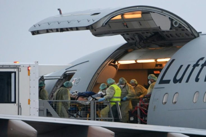 Medics transfer a coronavirus patient onto a medical transport plane at Memmingen Airport, Bavaria