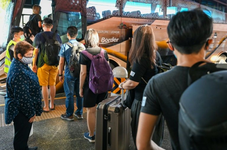 Vaccinated travellers in Singapore board the bus to Malaysia's southern state of Johor
