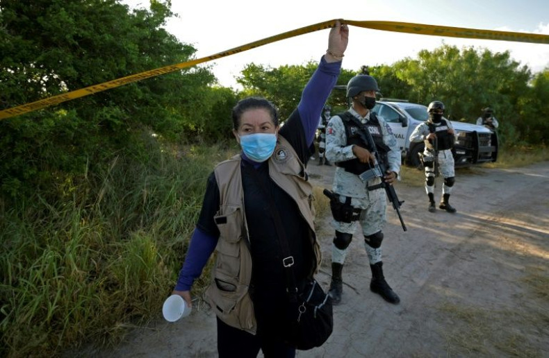 Maria Valdez, an activist and relative of a missing person, lifts barrier tape to allow other relatives to access a search site