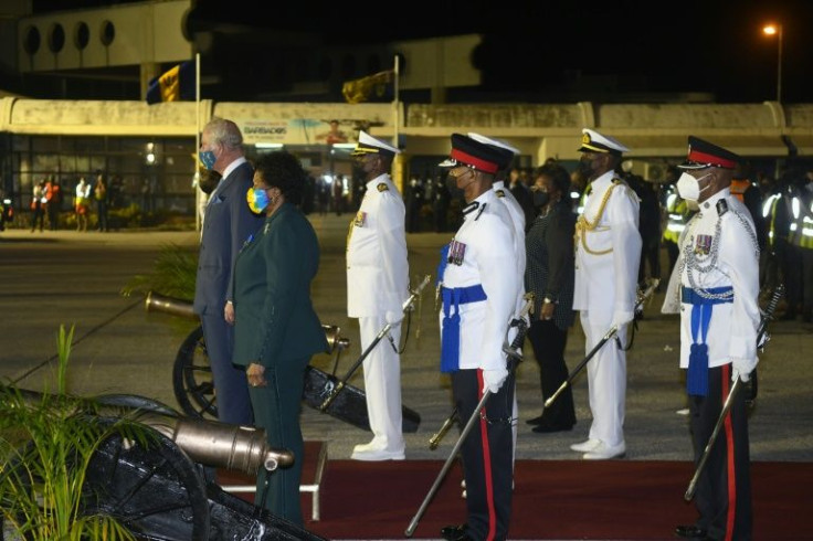 President-elect Sandra Mason (2L), Prime Minister Mia Amor Mottley (3R) and Prince Charles stand on parade at the airport in Barbados ahead of the country's transition to becoming a republic