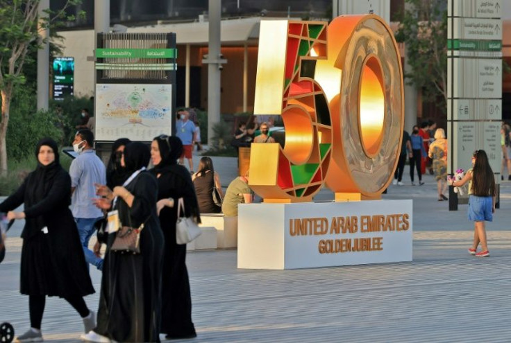 People walk next to a monument at Dubai Expo 2020, on November 28, 2021, celebrating the upcoming United Arab Emirates' 50th anniversary which falls on December 2