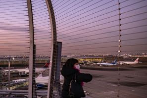 A woman looks on from the observation deck of Tokyo's Haneda international airport on November 29, 2021, as Japan announced plans to bar all new foreign travellers over the Omicron variant of Covid-19