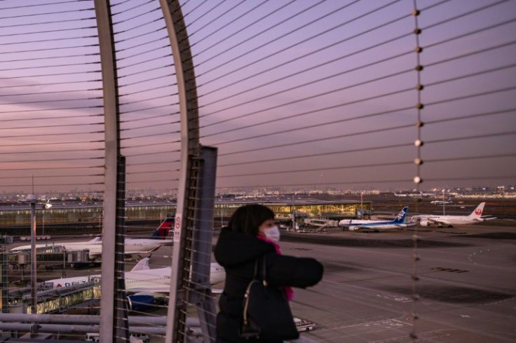 A woman looks on from the observation deck of Tokyo's Haneda international airport on November 29, 2021, as Japan announced plans to bar all new foreign travellers over the Omicron variant of Covid-19