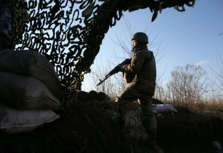 A Ukrainian serviceman keeps watch at a position on the frontline after Kiev accused Moscow of massing forces