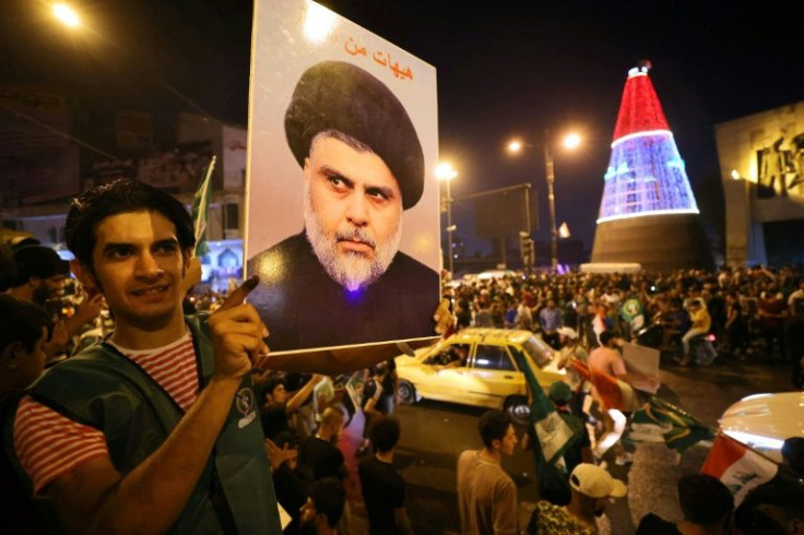 Supporters of Iraqi Shiite cleric Moqtada al-Sadr celebrate in Baghdad's Tahrir square on October 11, 2021 following the announcement of parliamentary elections' initial results