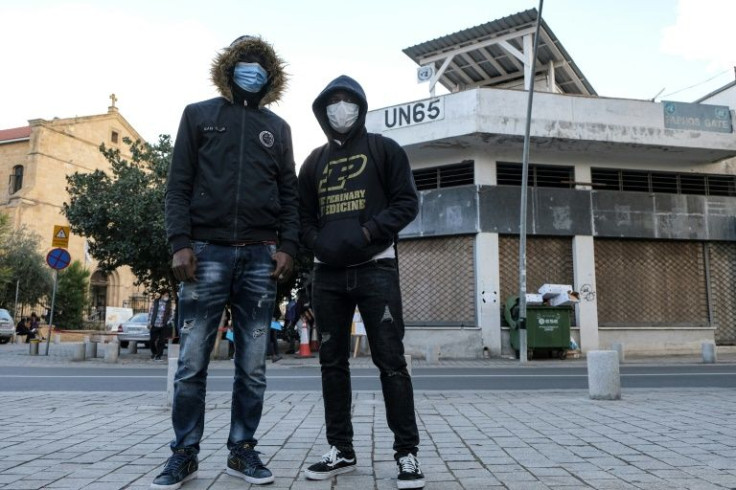 Two Liberian asylum seekers who crossed from the northern part of Cyprus pose for a photo in the divided city of Nicosia