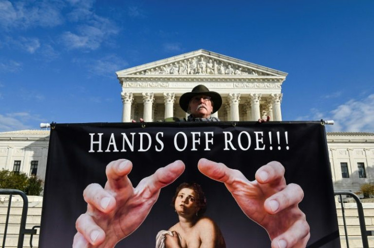 A man holds a sign supporting the preservation of abortion rights in front of the US Supreme Court