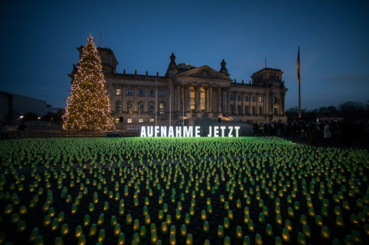 Thousands of green candles are lit in front of the Reichstag building in Berlin, in an action set up to draw attention to the refugees' situation at the Polish-Belarusian border.