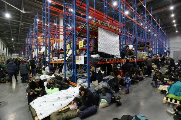 Migrants rest at the transport and logistics centre near the Bruzgi border point on the Belarusian-Polish border