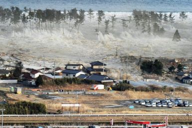 An aerial photo shows a residential area being hit by a tsunami in Natori, Miyagi prefecture