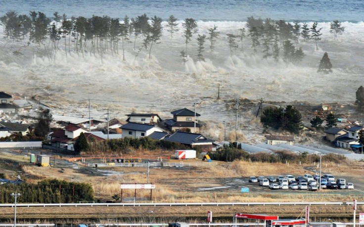 An aerial photo shows a residential area being hit by a tsunami in Natori, Miyagi prefecture