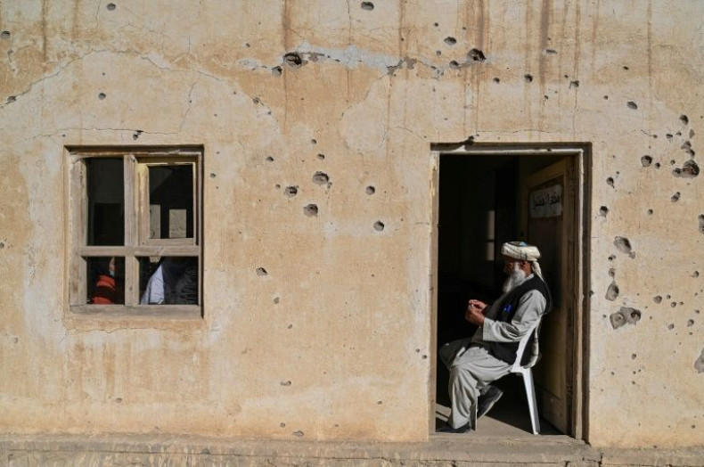 A teacher sits at the entrance of a classroom at a bullet riddled school in Arzo village on the outskirts of Ghazni