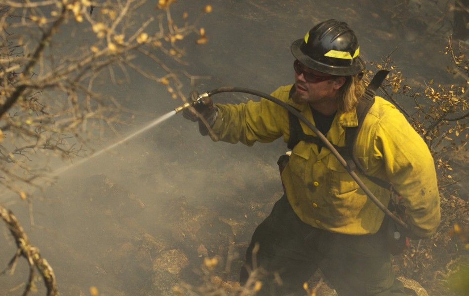 A wildland firefighter extinguishes a hot spot on the eastern edge of the Wallow Wildfire outside Alpine, Arizona