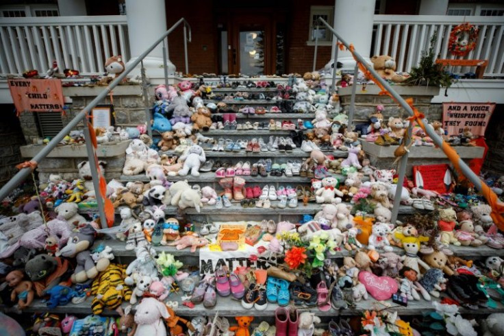 Children's shoes and stuffed animals sit on the steps as a tribute to the missing children of the former Mohawk Institute Residential School, in Brantford, Canada, November 9, 2021