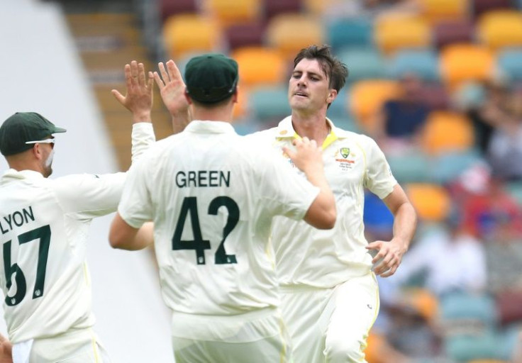 Pat Cummins (right) celebrates taking the wicket of Ben Stokes on his way to five wickets as England were 147 all out