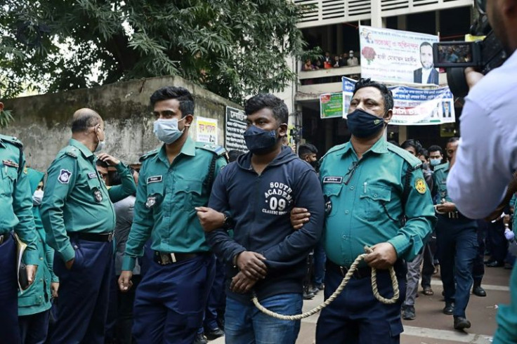 Police escort one of the convicted students after the sentencing in Dhaka
