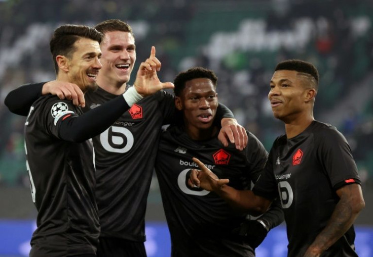 Lille players celebrate after beating Wolfsburg 3-1 to top their Champions League group