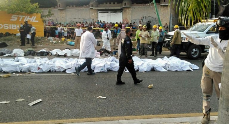 The bodies of migrants who died in a road accident are lined up on the pavement in Tuxtla Gutierrez, in Mexico's Chiapas state