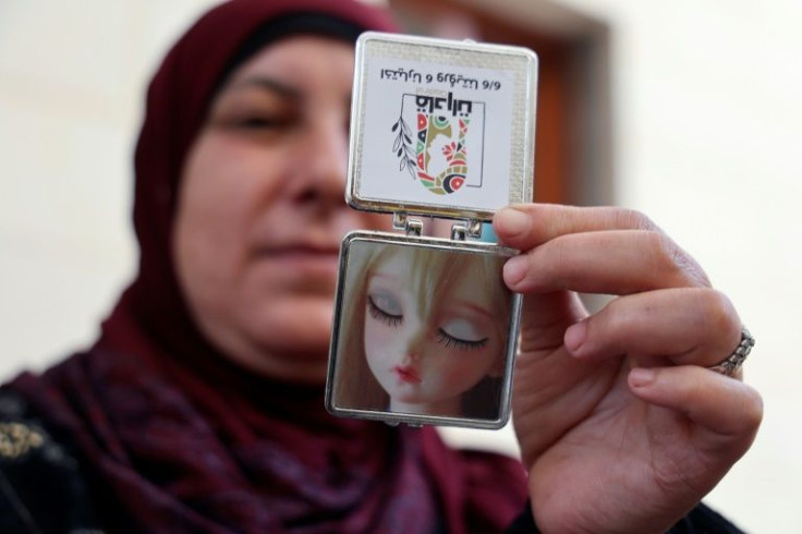 A candidate for Palestinian council elections shows a pocket mirror included in campaign merchandise that an all-woman list is offering as part of their distinctly feminine campaign merchandise