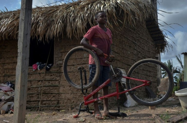 Gabriel Silva plays with a bicycle outside his house