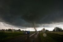Vehicles stop on the side of a road as a tornado rips through a residential area after touching down south of Wynnewood, Oklahoma on May 9, 2016