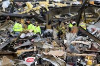 Emergency workers search what is left of the Mayfield Consumer Products Candle Factory after it was destroyed by a tornado in Mayfield, Kentucky, on December 11, 2021