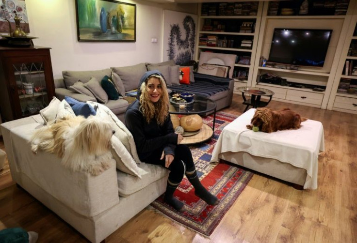 An Iranian woman sits with her dogs at home in northern Tehran