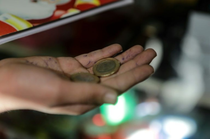 A Syrian boy shows Turkish coins while shopping in Syria's rebel-held city of Al-Bab, where Turkish money is the main currency but has plunged in value, adding to people's pain