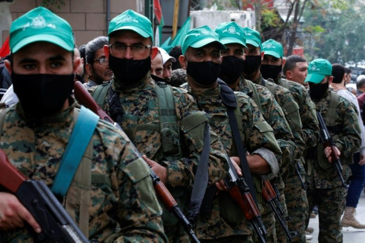 Fighters take part in a funeral procession for Hamza Ibrahim Shahin, a member of the Hamas movement, in the Burj al-Shamali camp for Palestinian refugees