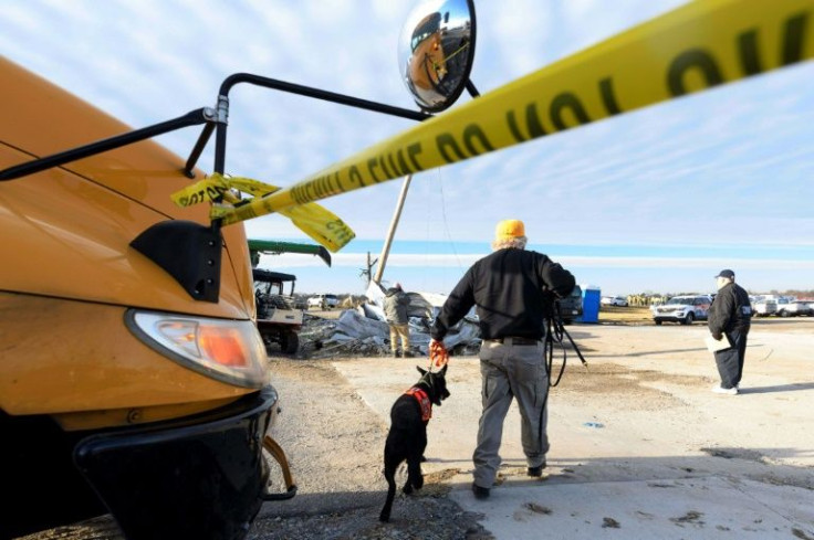 A searcher with a sniffer dog near the remains of the factory in Mayfield