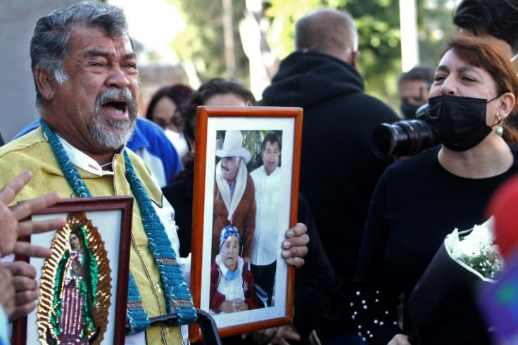 Fans of Mexican singer Vicente Fernandez sing his songs as they hold his picture and the image of the Virgin of Guadalupe, outside the hospital where he died in Guadalajara