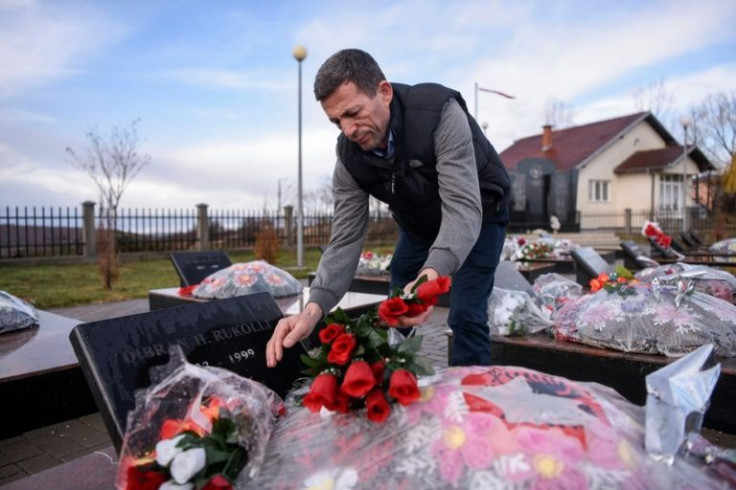 Vesel Rukolli visits the grave of his father and his relatives killed during the war