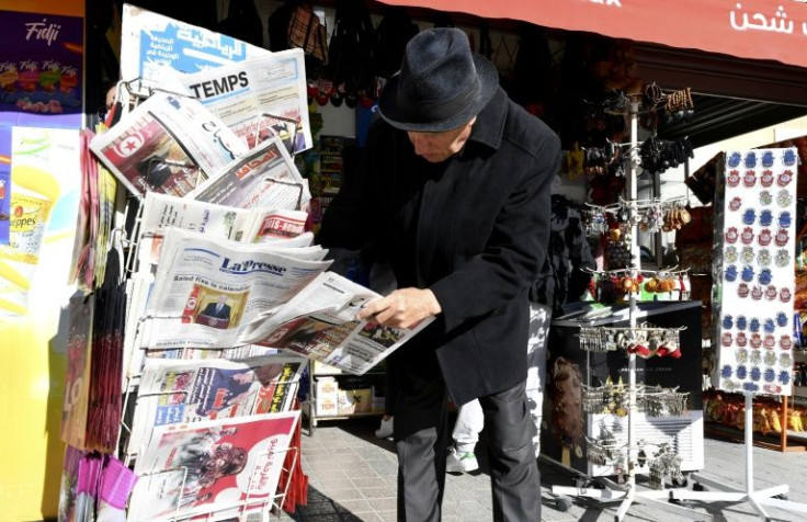 A Tunisian man checks newspapers on a stand on Habib Bourguiba Avenue in the capital Tunis on December 14, 2021