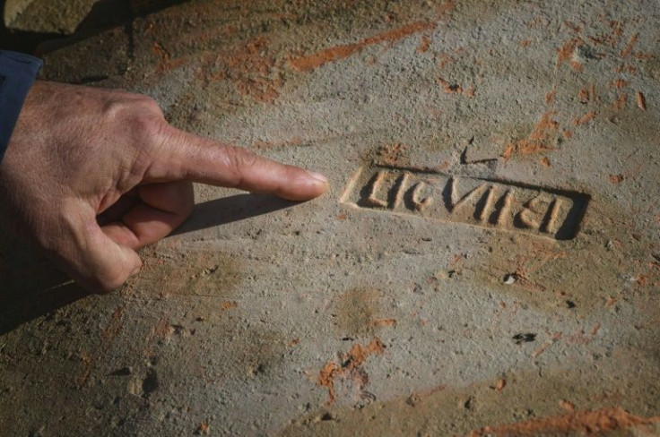 Archeologist Dragan Jacanovic points out a brick bearing a Roman stamp -- for centuries, locals have used the bricks, mosaic tiles and other pieces from antiquity found in the area for everyday needs